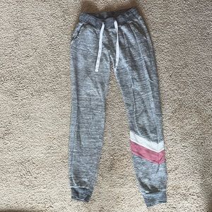 grey sweatpants with a pink and white stripe